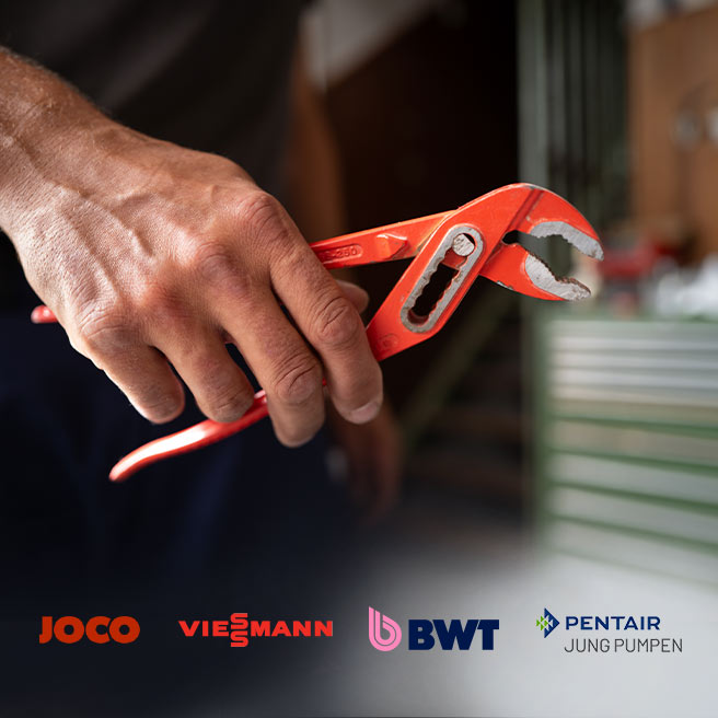 Ein Mitarbeiter der Firma Rolf Müller Haustechnik hält eine rote Zange in der Hand. 